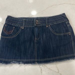Denim miniskirt with leather trim on pockets and fringed hem